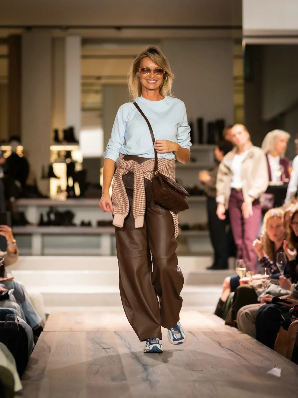 Roze trui met blauw T-shirt, bruine broek en blauwe sneakers