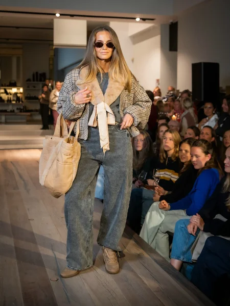 Bruin gilet met grijze broek, camel sneakers en beige shopper