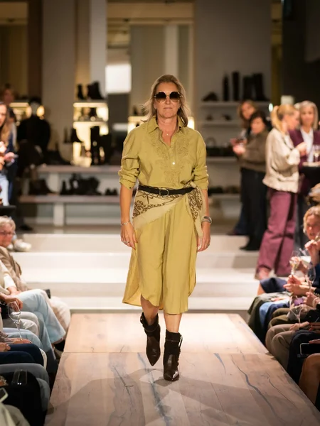 Beige jas met blauwe broek en beige schoenen